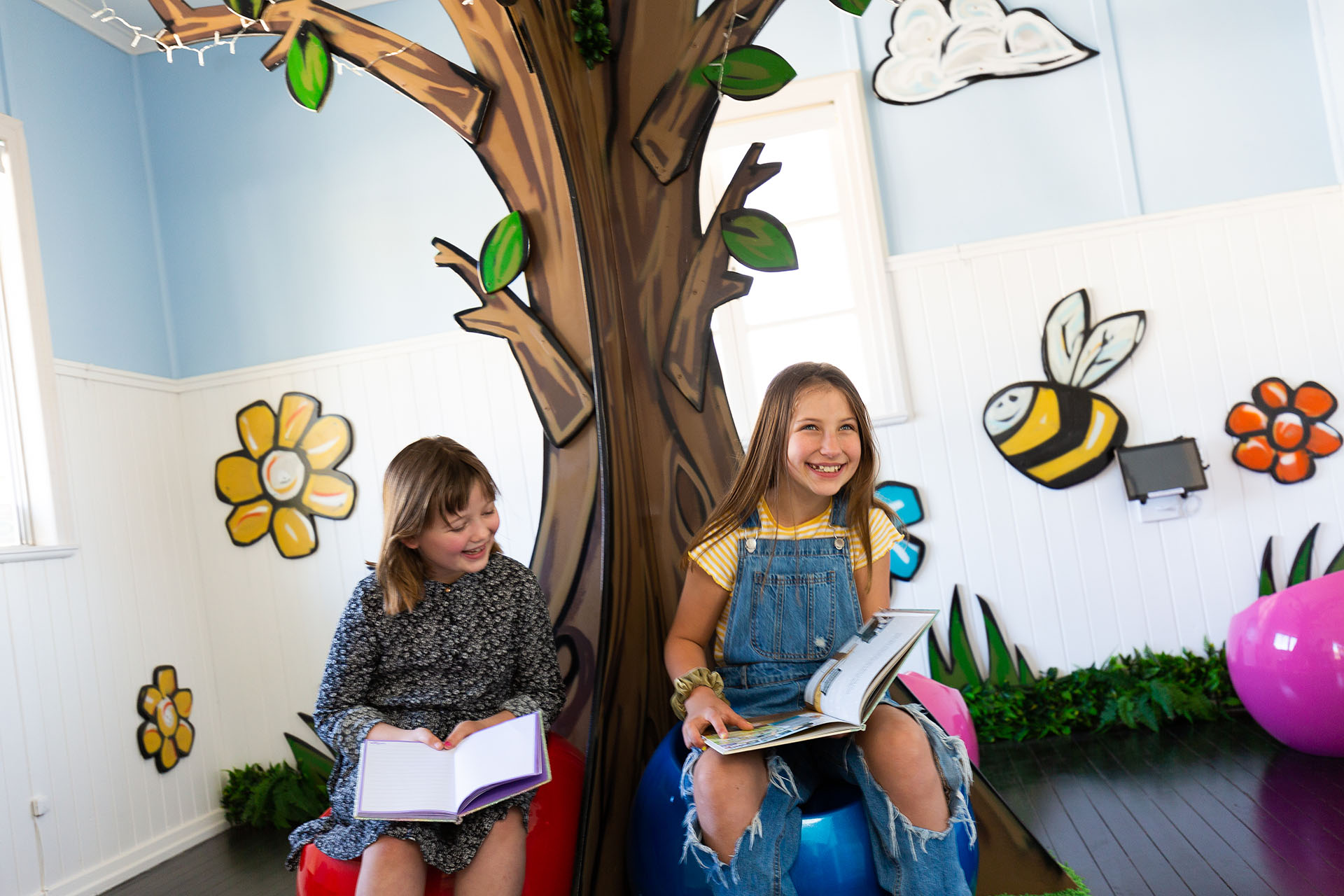 two young girls sitting in the waiting room of a children dentist in Sunshine Coast