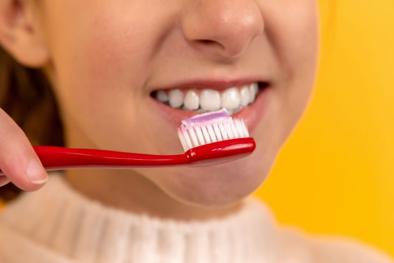 teeth whitening - girl brushing her teeth tooth crown