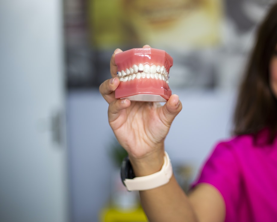 root canal treatment - woman holding false teeth