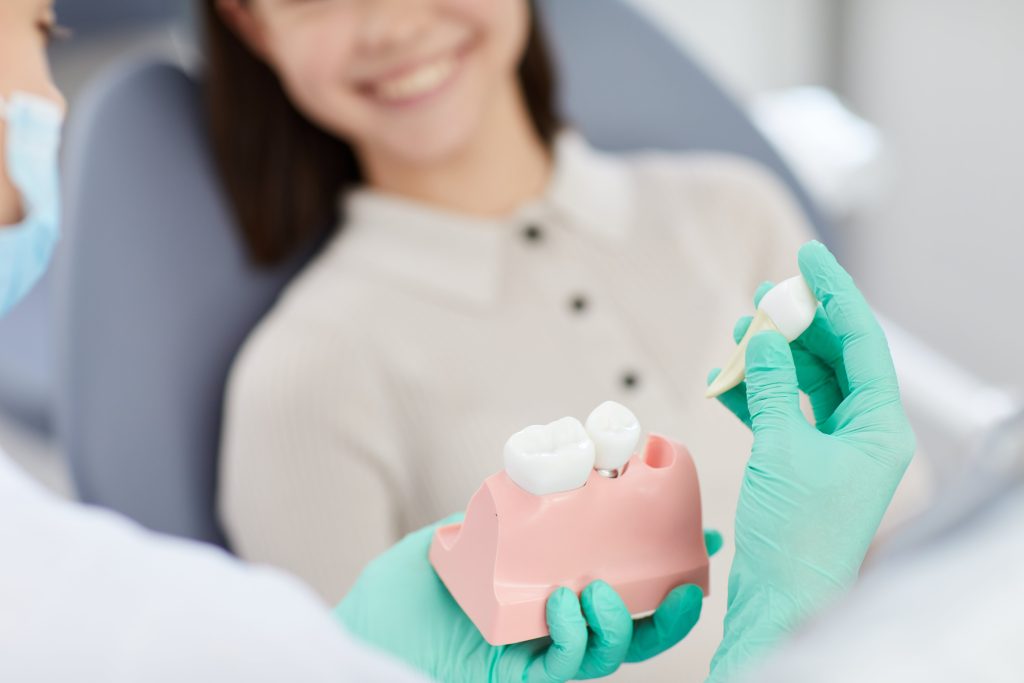 dental implants - Tooth extraction model being shown to dental patient